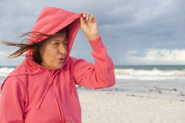 Mature woman autumn storm at beach