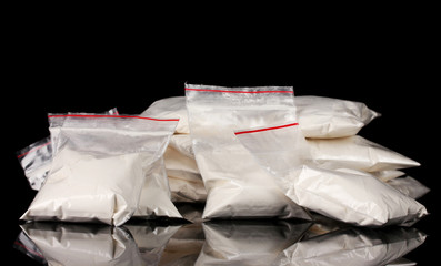 Cocaine in packages on black background - obrazy, fototapety, plakaty
