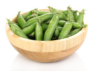 Green peas in wooden bowl isolated on white