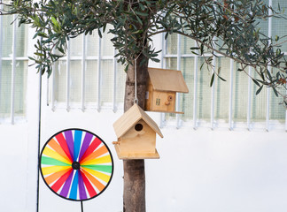 Birdhouse and windmill under tree in the garden