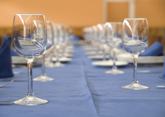 A table with a row of glasses and cutlery