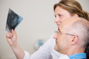 zahnärztin zeigt ein röntgenbild