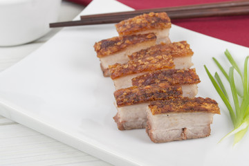 Siu Yuk - Chinese crispy roasted pork belly on a white platter.