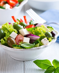 Bowl of green salad with feta cheese and  olives