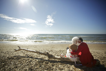 Bride and groom sitting by the sea
