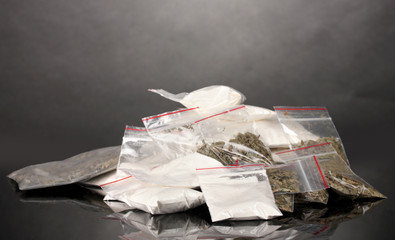 Cocaine and marihuana in packages on grey background