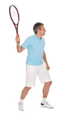 Mature man playing tennis