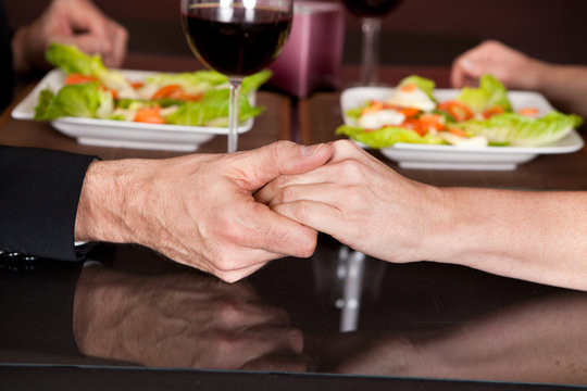 Touching hands at romantic dinner in restaurant