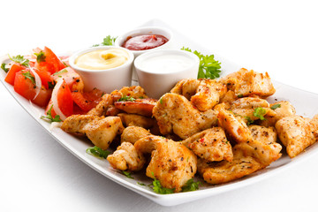 Grilled meat and vegetables on white background
