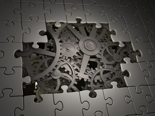 Gears coming out from underneath a jigsaw puzzle