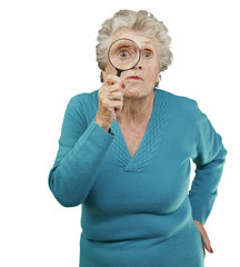 portrait of senior woman looking through a magnifying glass over