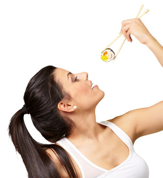 young pretty woman eating sushi over white background