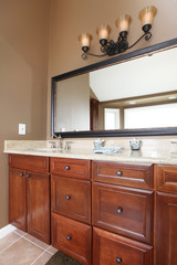 Close up luxury wood bathroom cabinets and mirror.