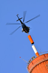 TV transmitter installation on the chimney with a helicopter. - obrazy, fototapety, plakaty