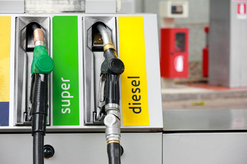 gasoline pump nozzles at petrol station - obrazy, fototapety, plakaty