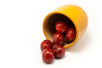 Juicy ruby red cherries in an orange cup