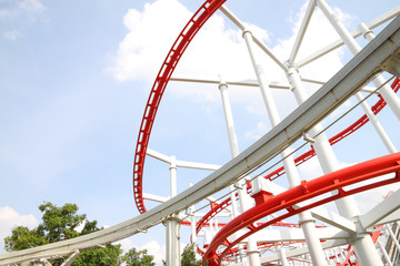 Curve of red and white roller coaster rail.