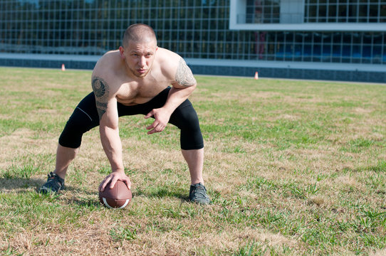 A male american football player placing a ball in playfield