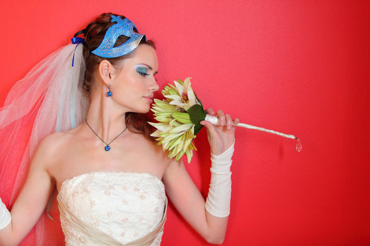 beautiful young bride with blue makeup and mask in hairdo