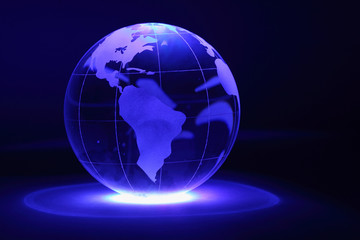 Small glass globe is illuminated by blue light from below