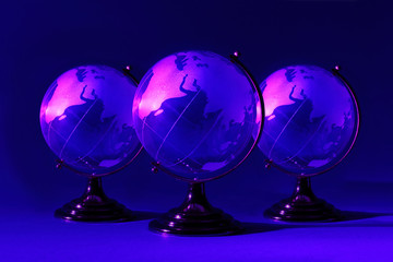 Three small blue glass globes at stand is illuminated