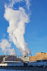Steam goes from thermal power plant pipes in the large city.