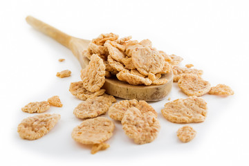 Corn flakes and wooden spoon isolated on white