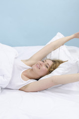 Woman stretching in bed