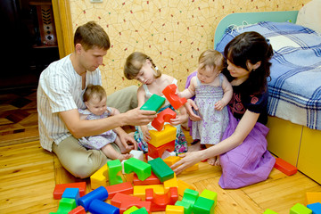 big family building a house  from toy cubes