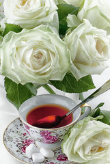Cup of tea and white roses