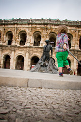 Enfant jouant devant les arènes de Nîmes