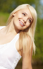 close-up portrait of beautiful young blond woman in white blouse
