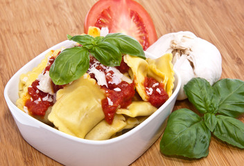 Bowl filled with Raviolis on wooden background