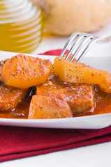 Fish with potatoes and black olives.