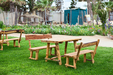 Green ecological cafe with wooden table with benches in tropics