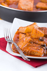 Fish with potatoes and black olives.