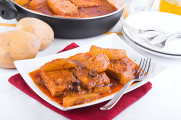 Fish with potatoes and black olives.