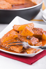 Fish with potatoes and black olives.