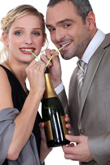 Couple drinking champagne through straw