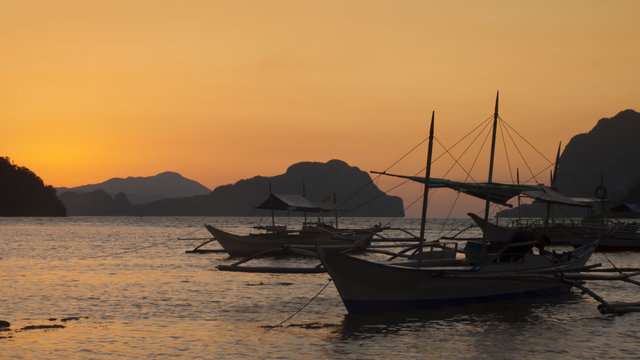 boats moored at coastal sunset
