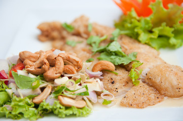 Deep fried fish serve with spicy salad and vegetables