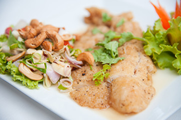 Deep fried fish serve with spicy salad and vegetables