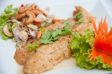 Deep fried fish serve with spicy salad and vegetables