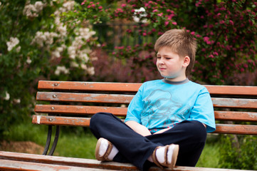 Sad boy sitting on a bench