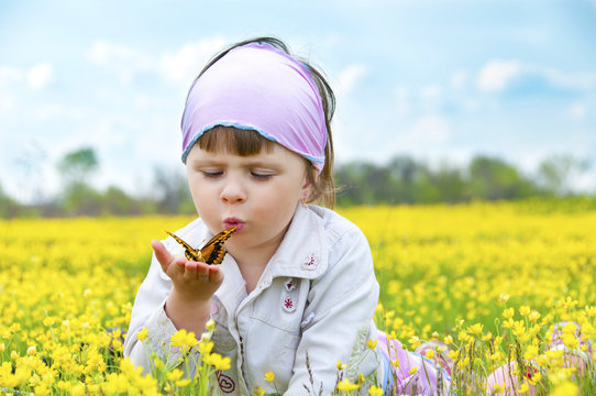 Little cute girl in a field of beautiful yellow flowers.