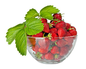 Fresh strawberries in glass bowl with green leaf isolated on whi