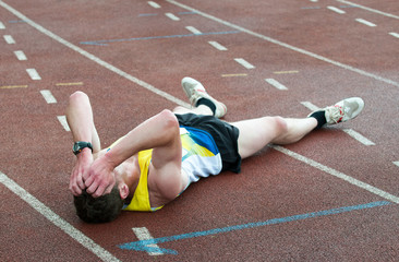 man lying on the ground at sport