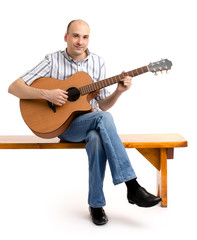 Obraz premium Handsome casual man with guitar sitting on bench