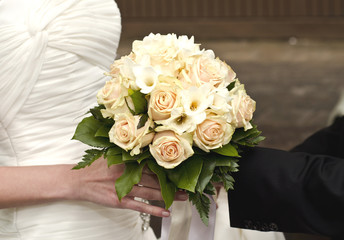 Wedding bouquet in hands of the bride and groom