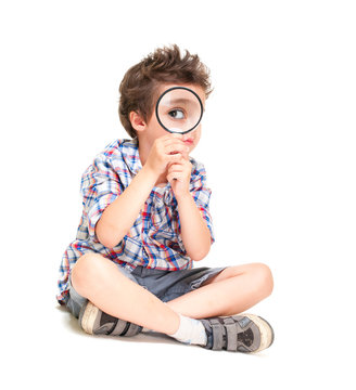 Attentive little boy with weird hair researching using magnifier